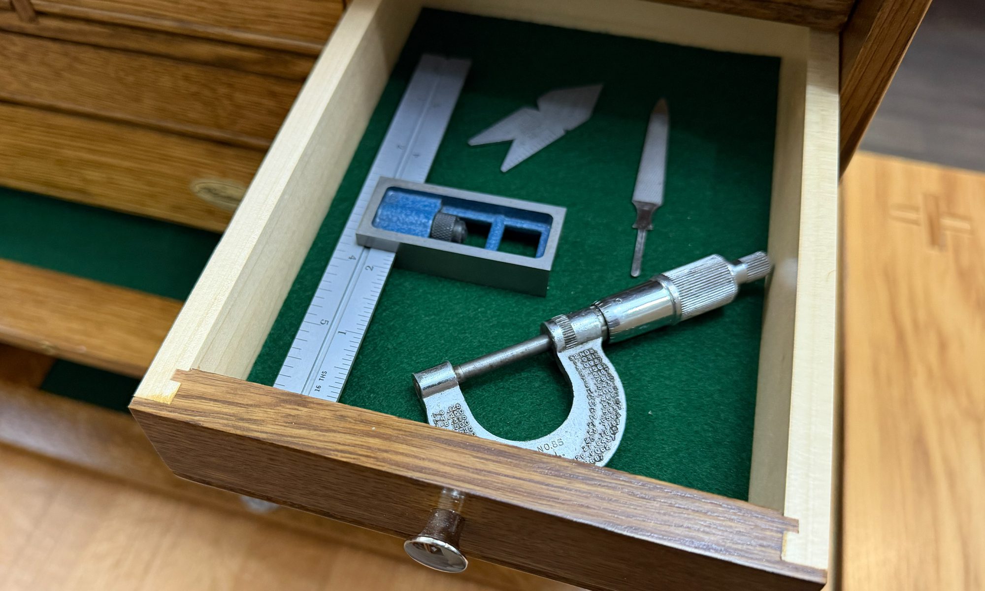 Felt-lined wooden drawer protecting precision tools from moisture